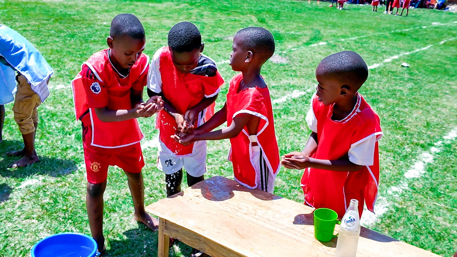 Learners in red uniforms take part in a table activity.