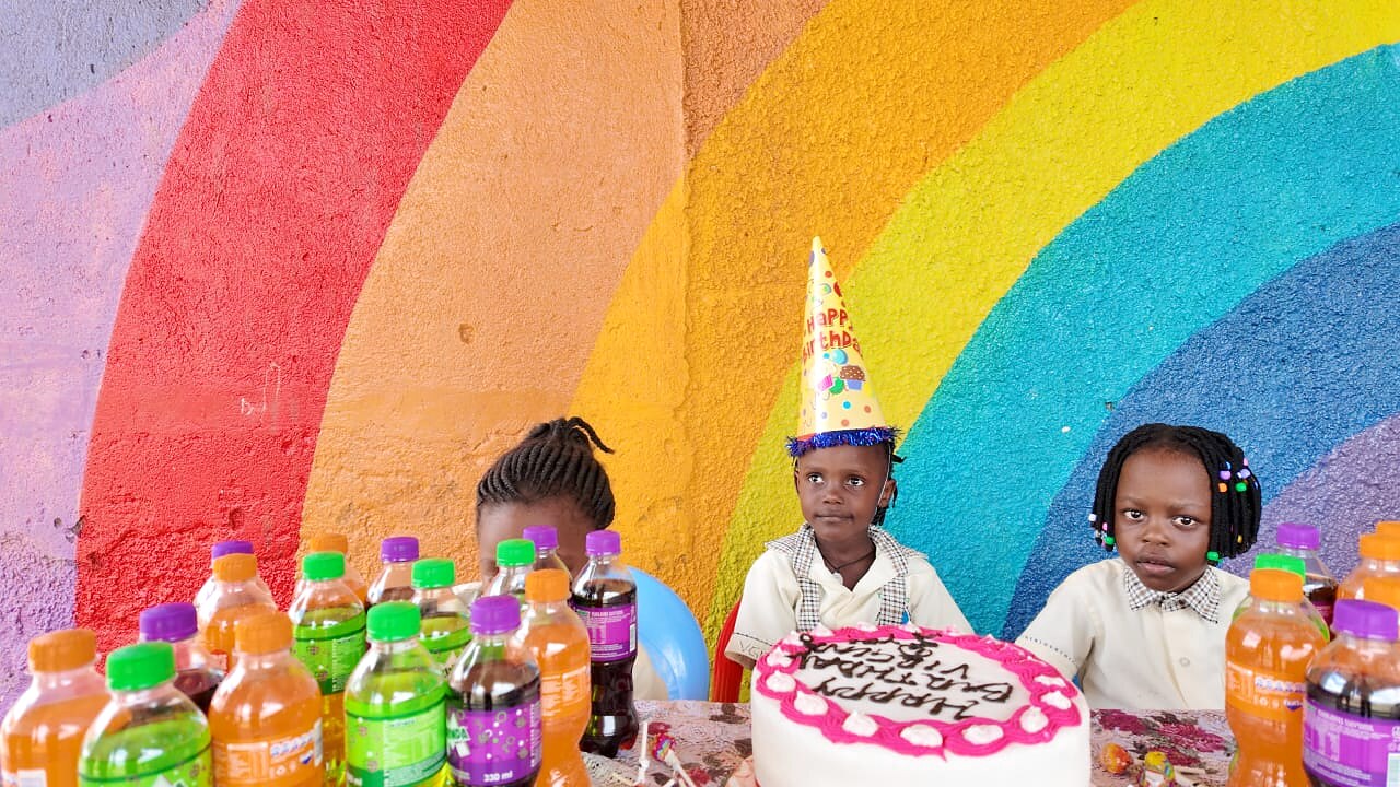 Children celebrate with a birthday cake at school.