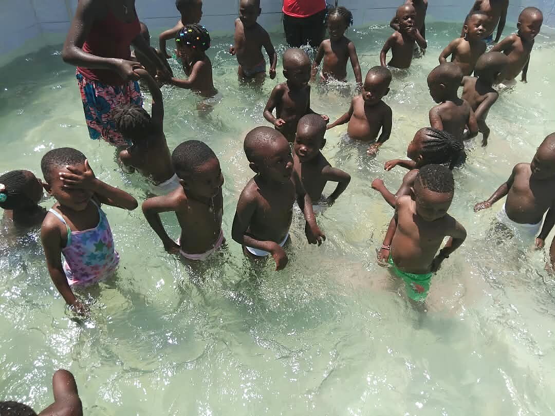 Children take part in water play in a pool.